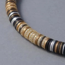 Naszyjnik z czarnych koralików i krążków w złocie i srebrze. PLACE DE LA NATION