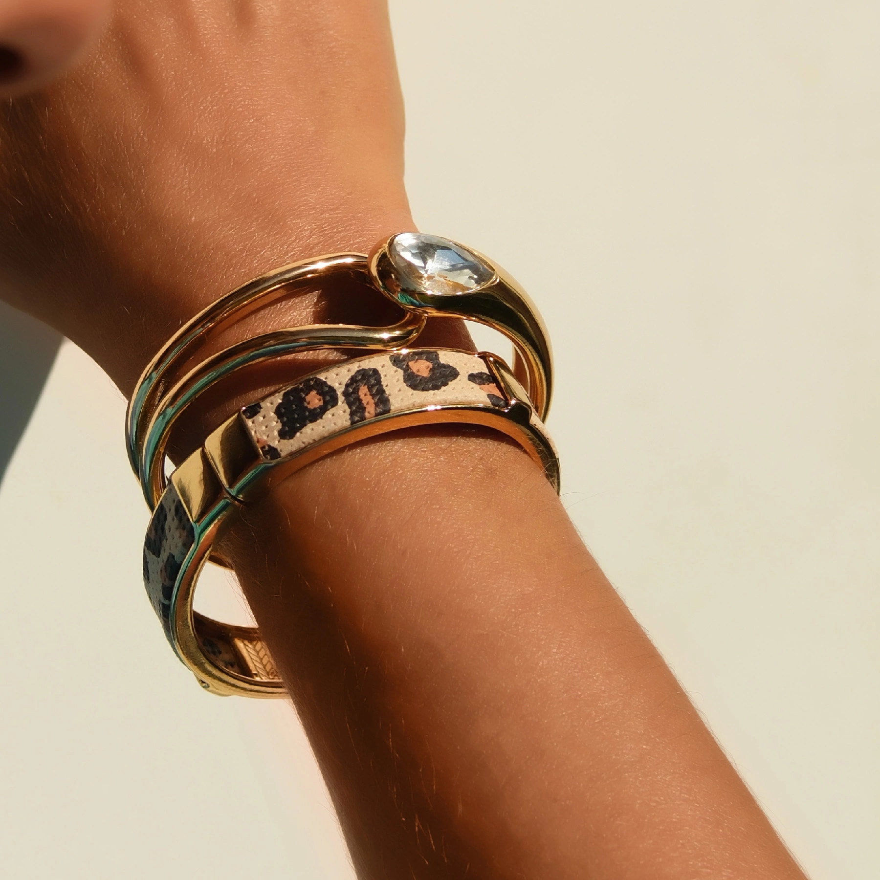 Sztywna pozłacana bransoleta z przezroczystym kryształem. KROPLA IGUAZU