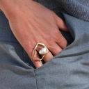 Regulowany złocony pierścionek z dekorem z perłą. PORUSZONY KADR