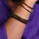 Sztywna złocona bransoletka z dekorem w formie łańcuchów. BASTIA