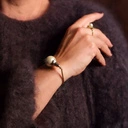 Złocona bransoletka z perłą bawłenianą w objęciu liści. PERŁA RIWIERY