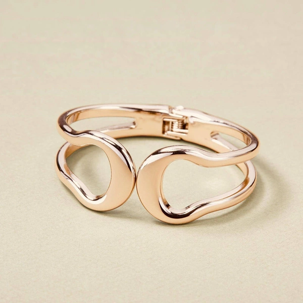 Sztywna otwierana bransoletka w kolorze złotym. ZBLIŻENIE