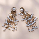 Kolczyki z dużą perłą na bazie i małymi na zawieszce. SEGRETO