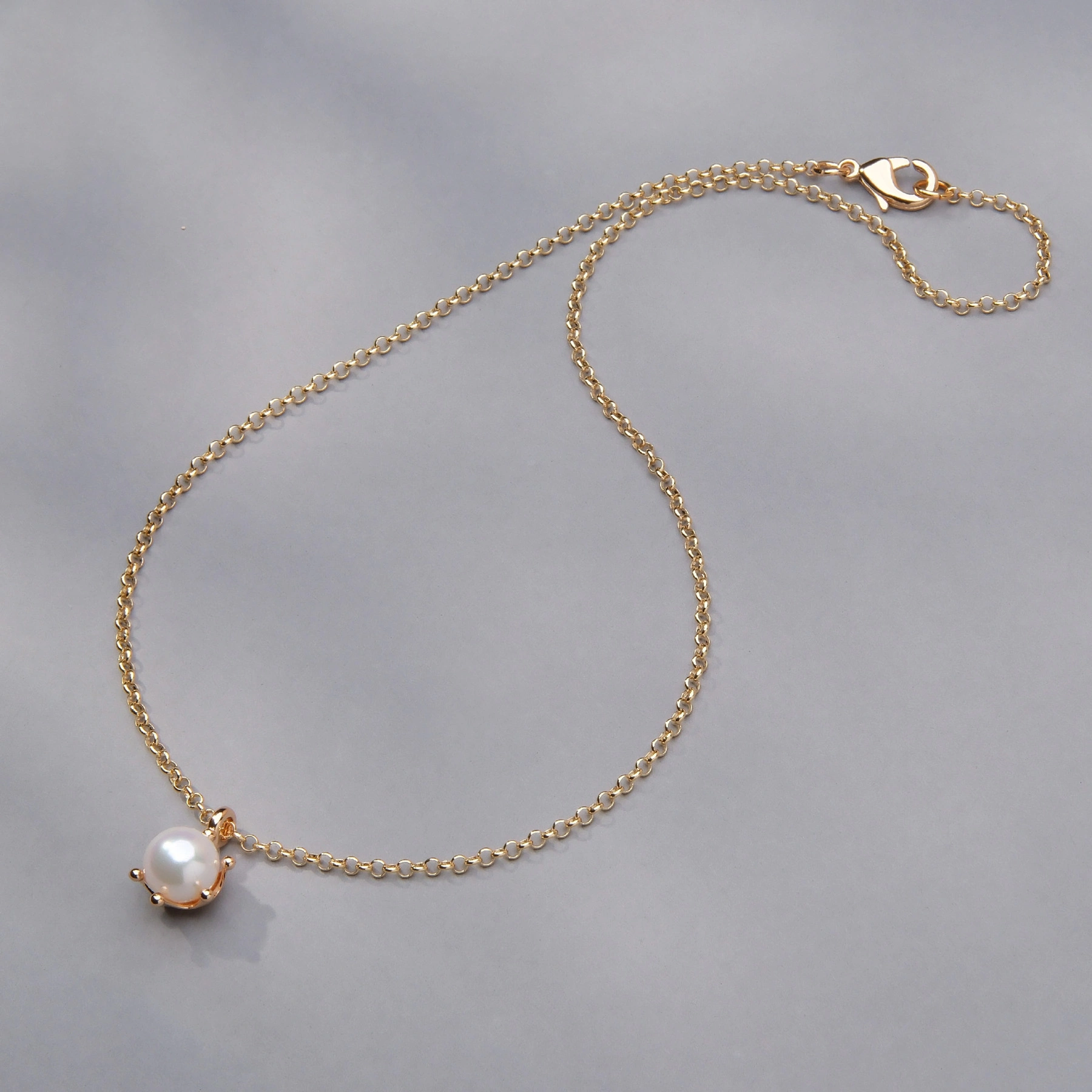 Złocony naszyjnik ze szklaną białą perłą w koronie. HISZPAŃSKIE RYTMY