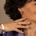 Sztywna, złota bransoletka ozdobiona białą skórką. KLASA W SOBIE