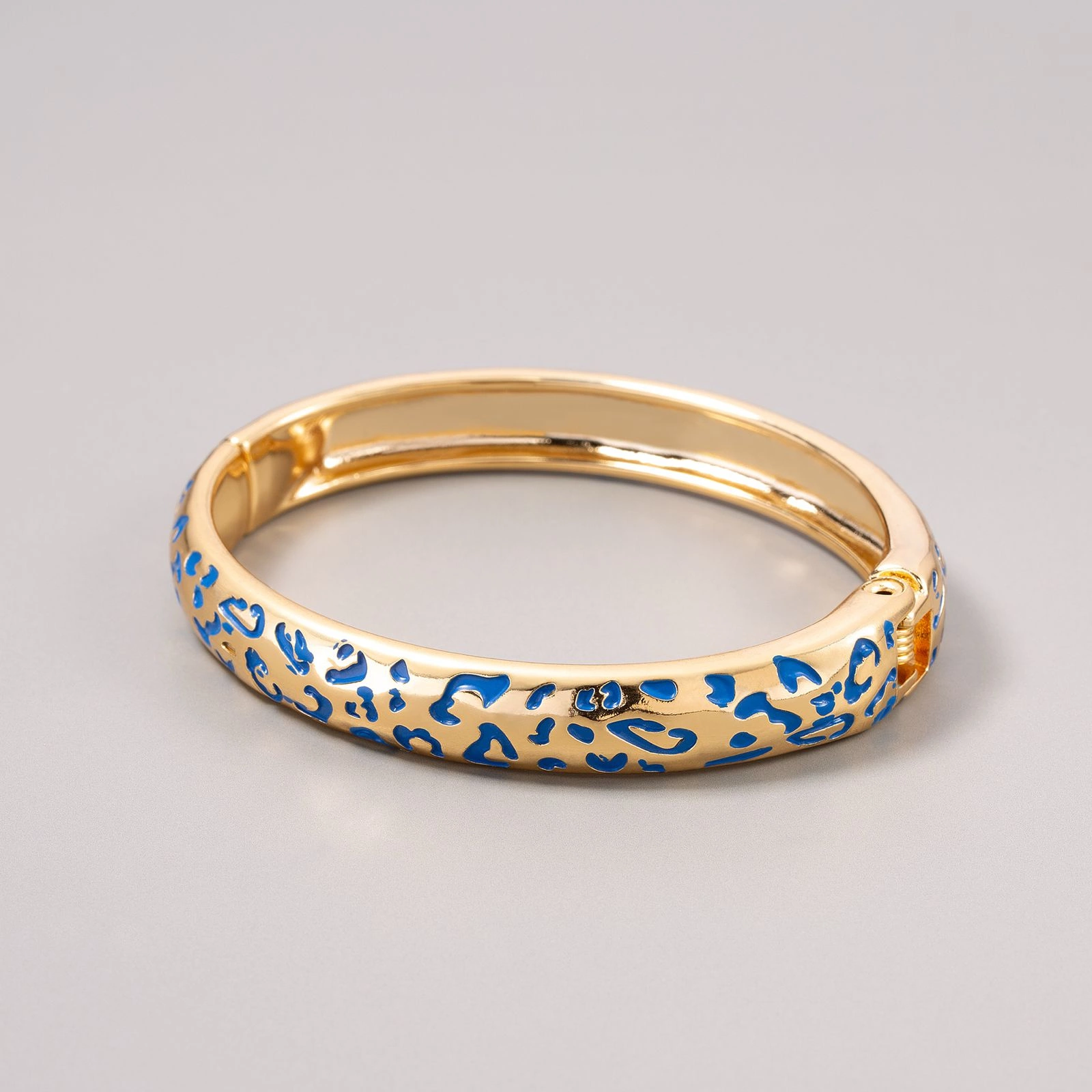 Sztywna pozłacana bransoletka z niebieskimi cętkami pantery. NIEBIESKA PANTERA