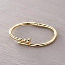 Sztywna bransoletka w kształcie zagiętego gwoździa. POZYTYWNY GWOŹDZIK