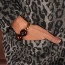 Sztywna złota bransoletka z dwiema brązowymi kulami. KOCHAM BRĄZ