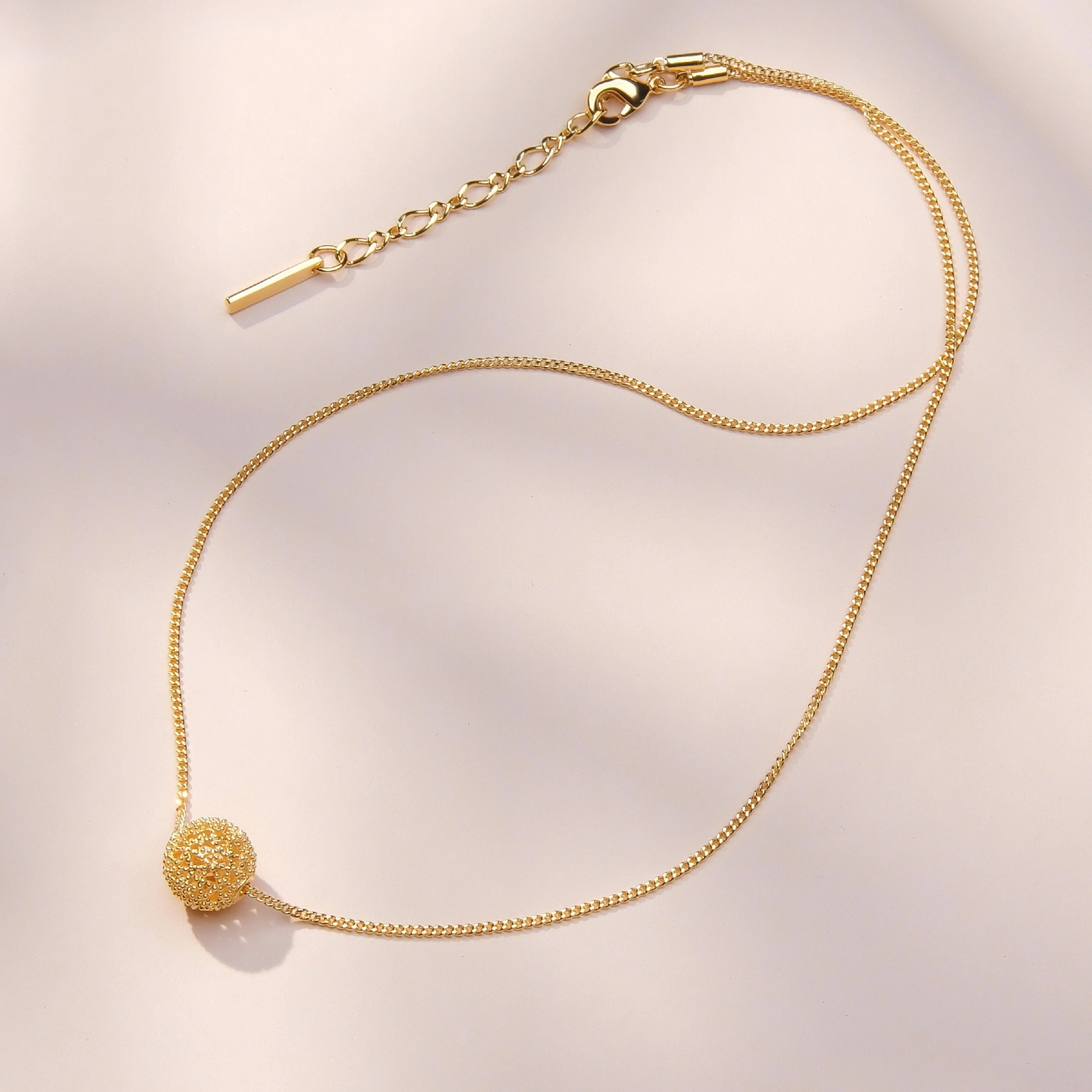 Pozłacany naszyjnik z ażurowym kulistym dekorem. ODDECH RIWIERY