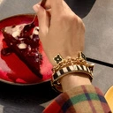 Złocona bransoletka z czarnymi kwiatkami na łańcuchu. LETNIA INSPIRACJA