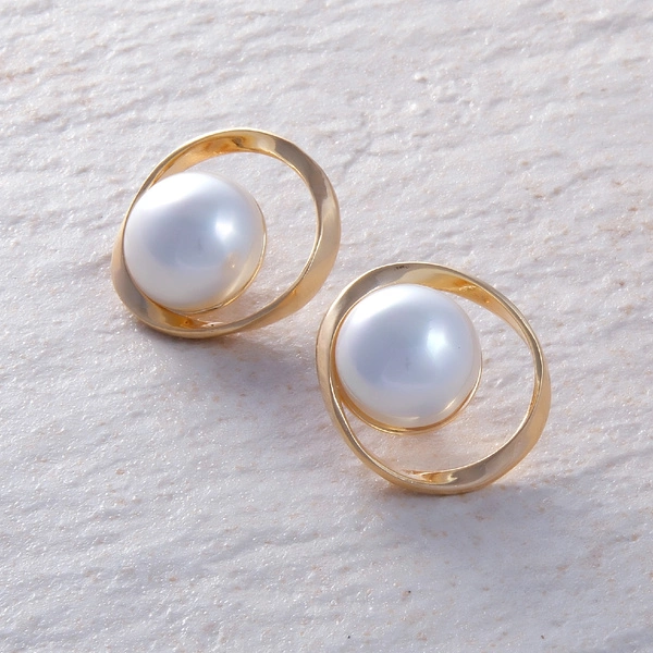 Pozłacane kolczyki w kształcie owalu z okazałą perłą. PEROLA