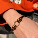 Sztywna bransoletka z głowami jaguarów i ringiem. AMBRA