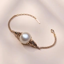 Złocona bransoletka z perłą bawłenianą w objęciu liści. PERŁA RIWIERY