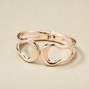 Sztywna otwierana bransoletka w kolorze złotym. ZBLIŻENIE