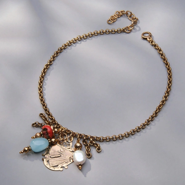 Złocony naszyjnik z zawieszką w formie herbu i kamieniami. STORIA DELLA FAMIGLIA