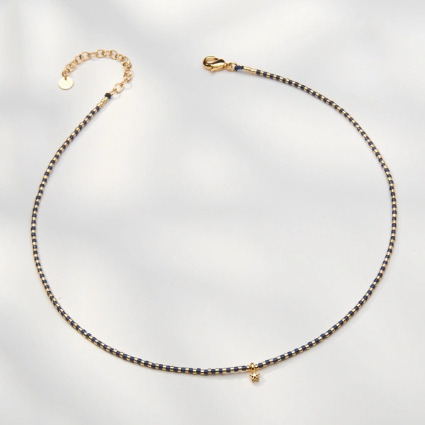 Naszyjnik z czarnych i złoconych koralików z gwiazdką. LA ESTRELLA DEL LEON