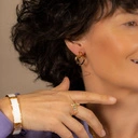 Sztywna, złota bransoletka ozdobiona białą skórką. KLASA W SOBIE