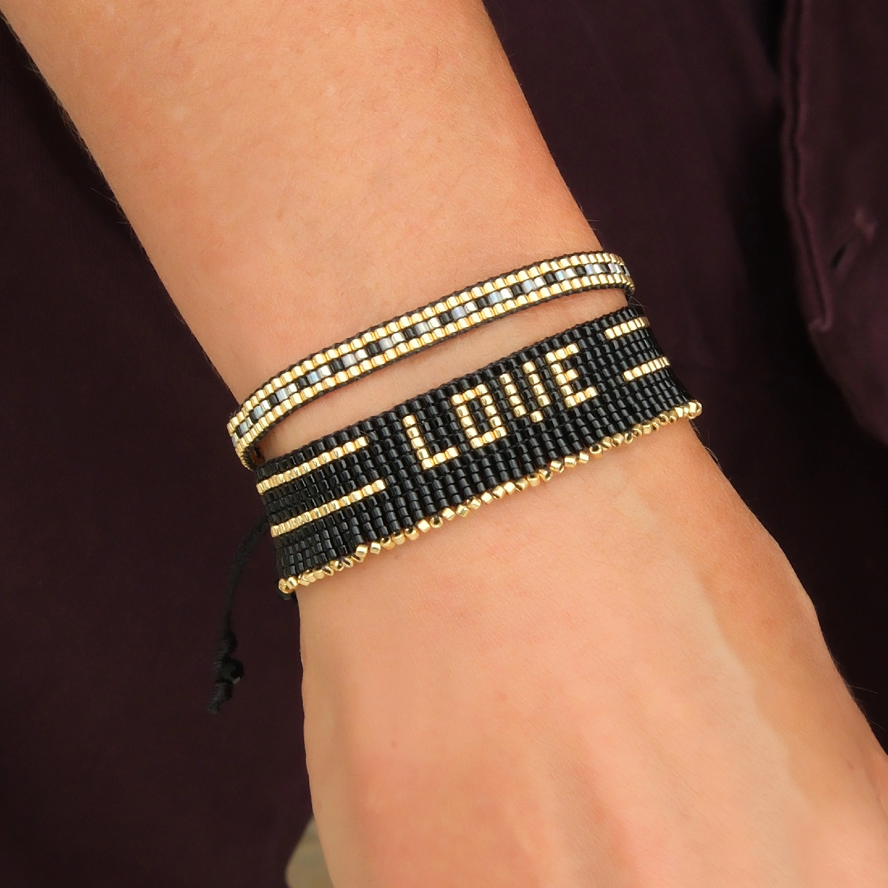 Bransoletka z czarnych paciorków Miyuki ze złotym napisem. CZUŁOŚCI W CIEMNOŚCI