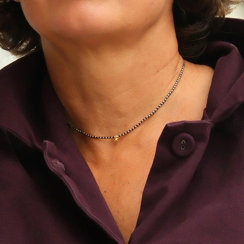 Naszyjnik z czarnych i złoconych koralików z gwiazdką. LA ESTRELLA DEL LEON