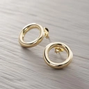 Drobne pozłacane kolczyki w kształcie zamkniętych kółek. PUELLA