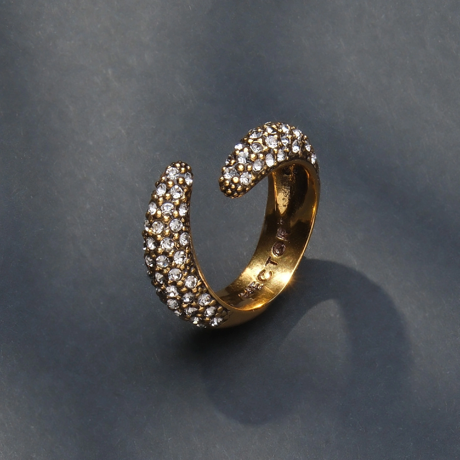 Szeroki otwarty pozłacany pierścionek z kryształkami. W OBJĘCIACH ŚWIATŁA