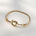 Sztywna złocona bransoletka z dekorem w formie serca. Z WŁASNEJ WOLI