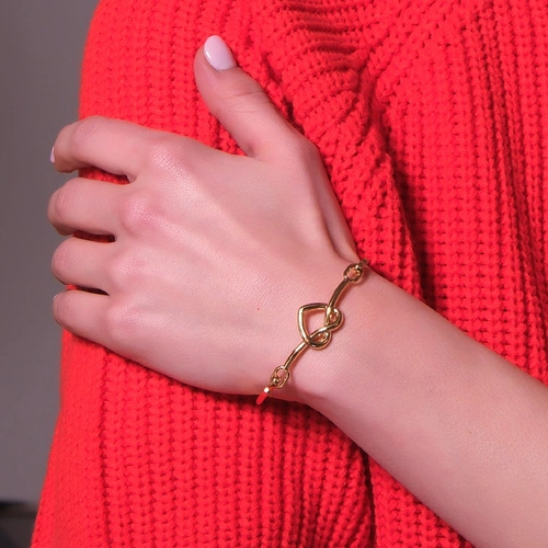 Sztywna złocona bransoletka z dekorem w formie serca. Z WŁASNEJ WOLI