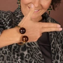 Sztywna złota bransoletka z dwiema brązowymi kulami. KOCHAM BRĄZ