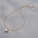 Złocony naszyjnik ze szklaną białą perłą w koronie. HISZPAŃSKIE RYTMY