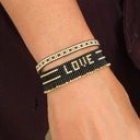 Bransoletka z czarnych paciorków Miyuki ze złotym napisem. CZUŁOŚCI W CIEMNOŚCI