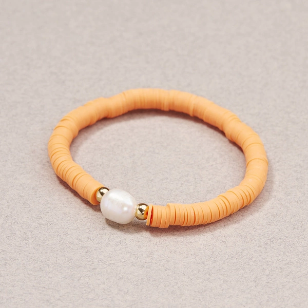 Bransoletka na gumce z perłą i pomarańczowymi koralikami. BRZOSKWINKA
