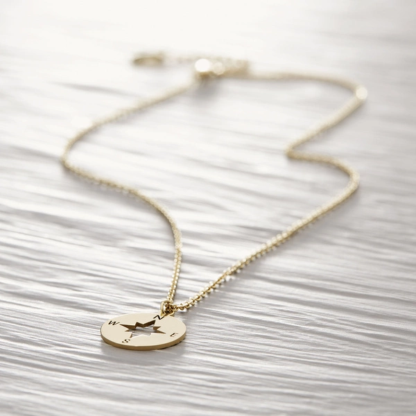 Krótki wisiorek z okrągłą zawieszką z motywem kompasu. STRONY ŚWIATA