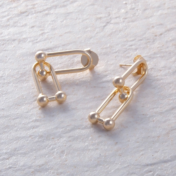 Pozłacane kolczyki wiszące w kształcie dwóch szekli. COSTA VERDE