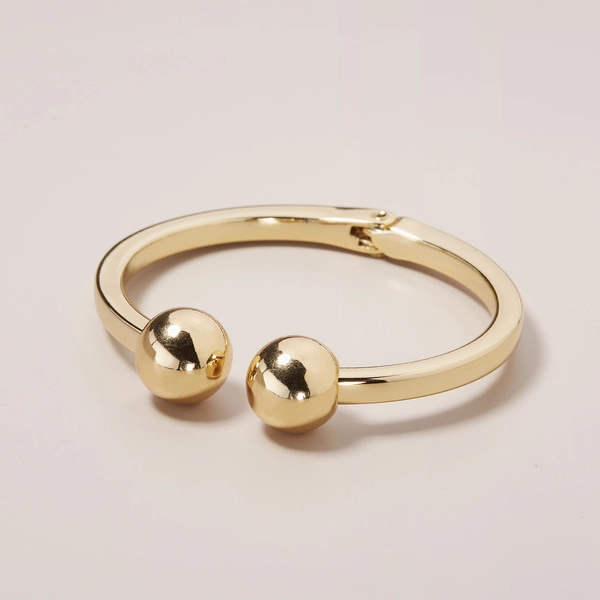 Sztywna złocona bransoletka z dwiema lekkimi kulkami. ZŁOTE GLOBY