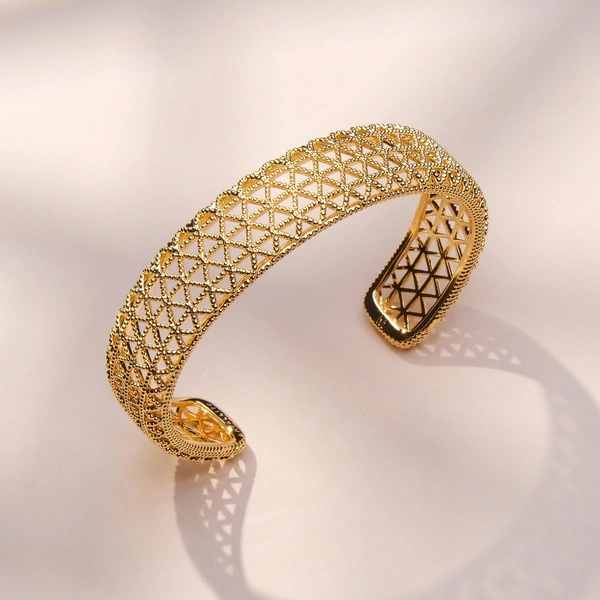 Wąska sztywna pozłacana bransoletka z ażurowym wzorem. PRZEŚWITY SŁOŃCA