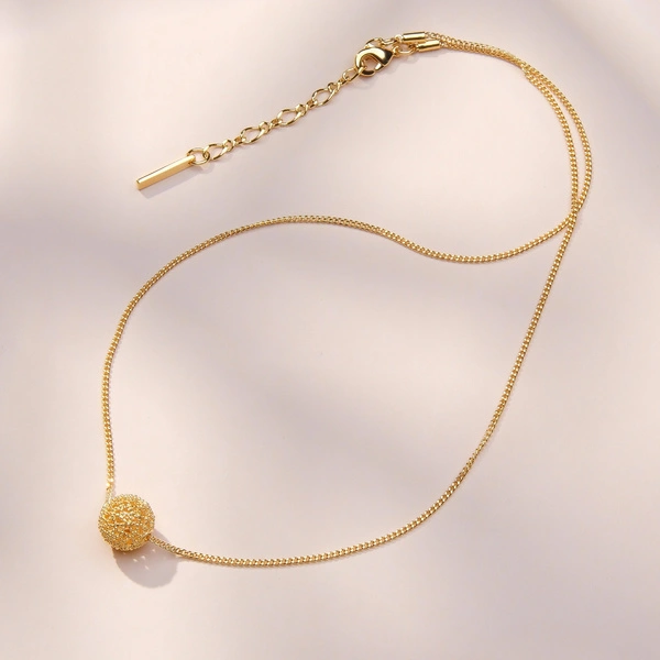 Pozłacany naszyjnik z ażurowym kulistym dekorem. ODDECH RIWIERY