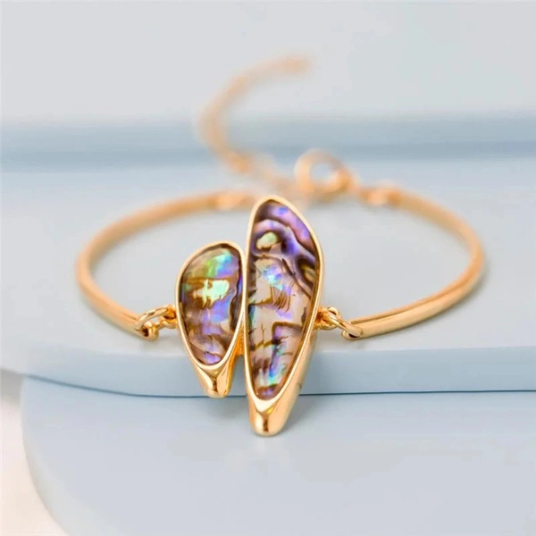 Sztywna złocona bransoletka z dekorem z muszli abalone. MUSZĘ MUSZLE